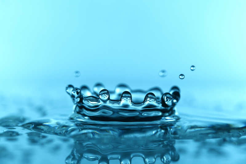 蓝色背景下皇冠形状的水滴