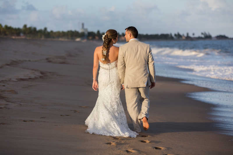 沙滩上散步的新郎和新娘