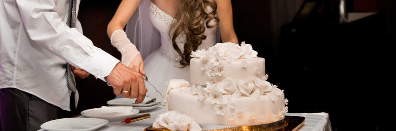 在切蛋糕的新婚夫妇