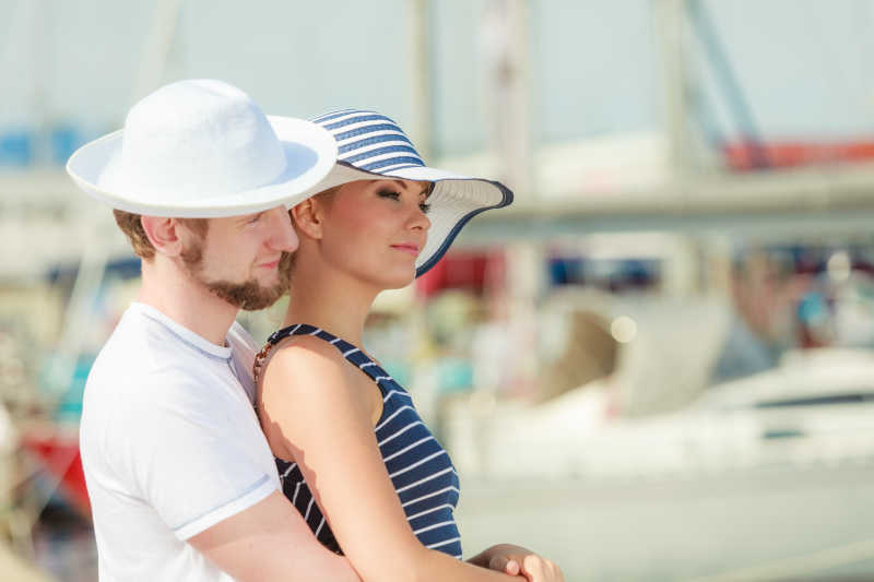 站在游艇码头上的年轻旅游夫妇