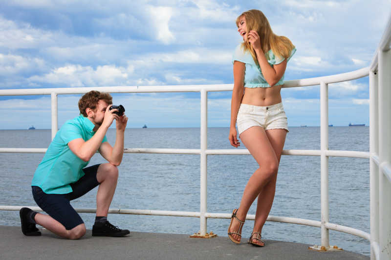 热恋的年轻情侣在码头上拍照