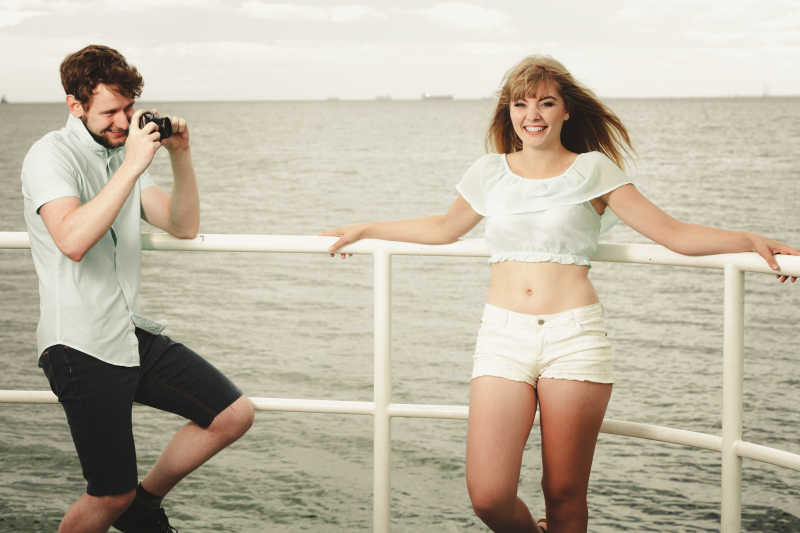 相爱的年轻情侣在码头拍照