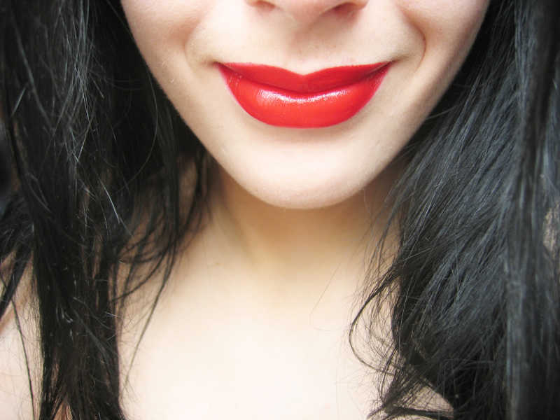 诱人的鲜红色的嘴唇卷曲的年轻女人