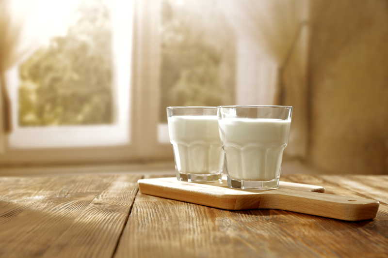 桌子上的玻璃杯装着两杯牛奶