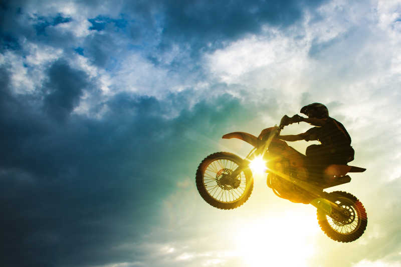 赛车手驾驶摩托车跳跃在高空
