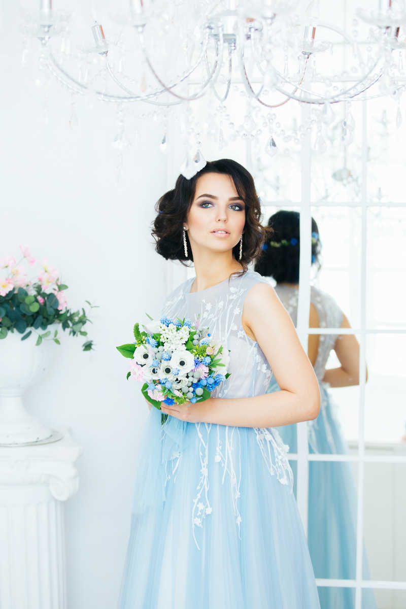 穿蓝色纱裙拿捧花的美丽新娘