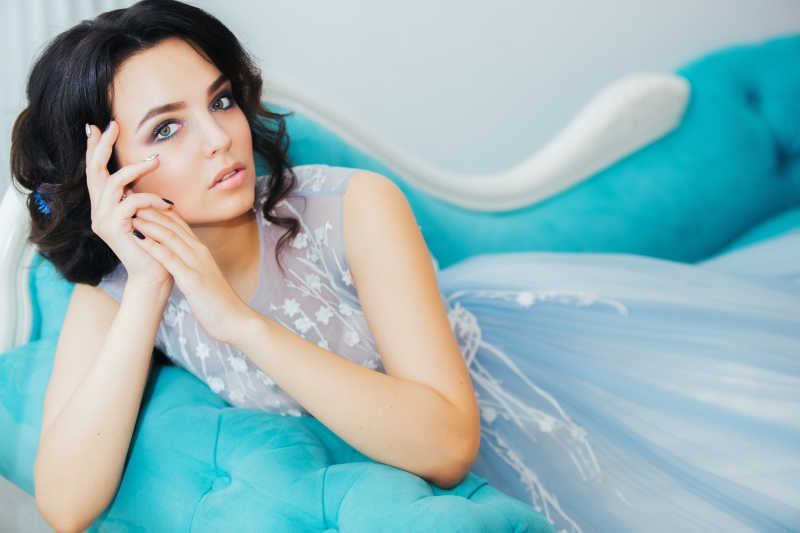 蓝色沙发上躺着的美丽新娘
