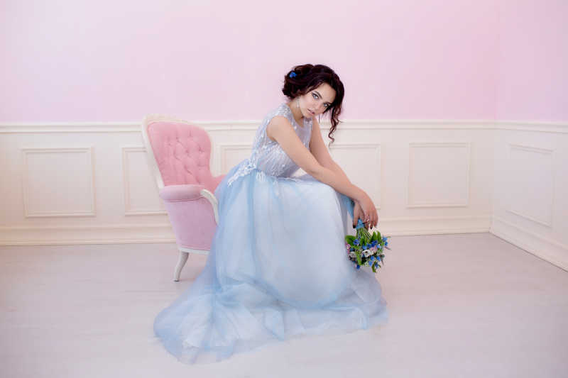 在粉色椅子上坐着的美丽新娘