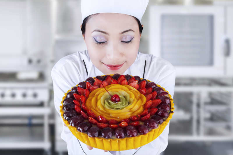 女厨师拿水果蛋糕