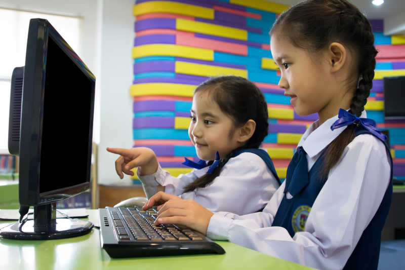 可爱的亚洲女孩使用电脑