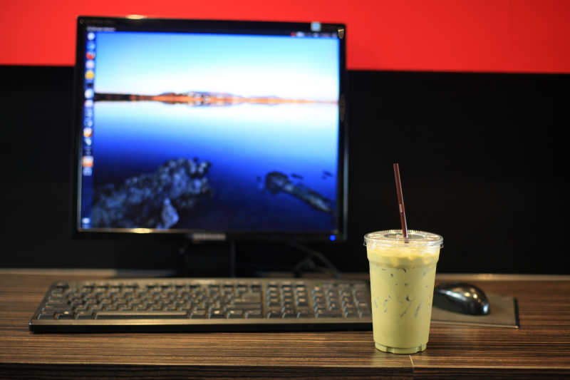 台式电脑前的冰奶茶