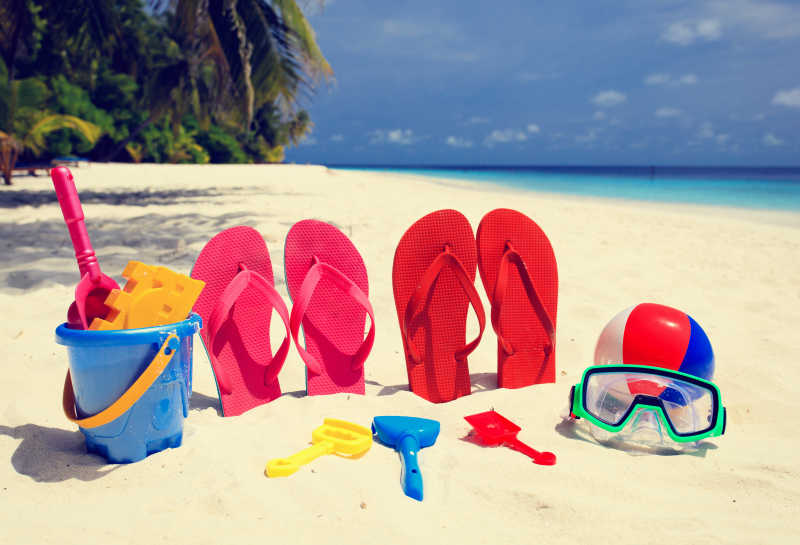 沙滩上的彩色拖鞋和玩具