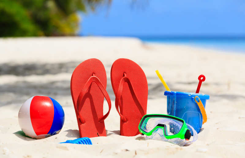 沙滩上的彩色拖鞋和各种玩具