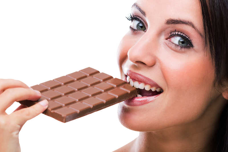 一个女人微笑着吃巧克力
