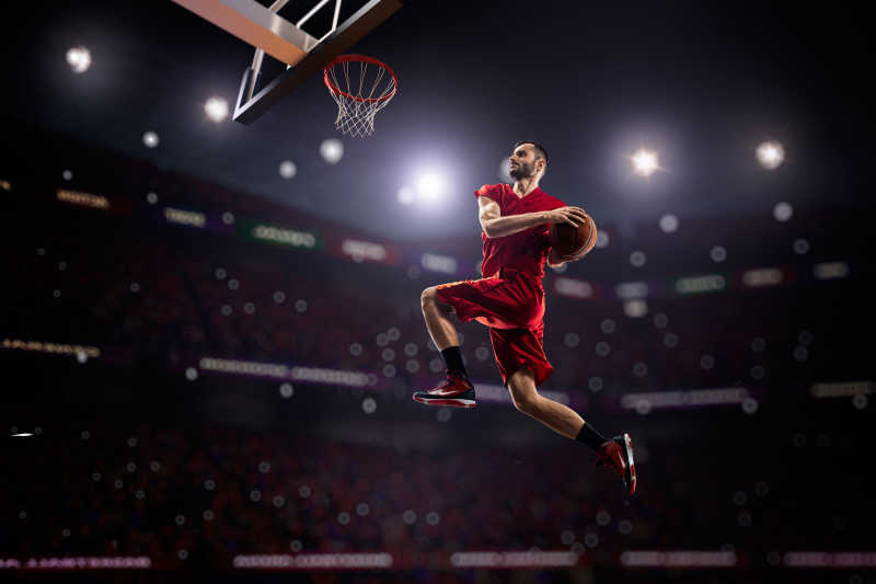 红衣篮球运动员抱球灌篮特写