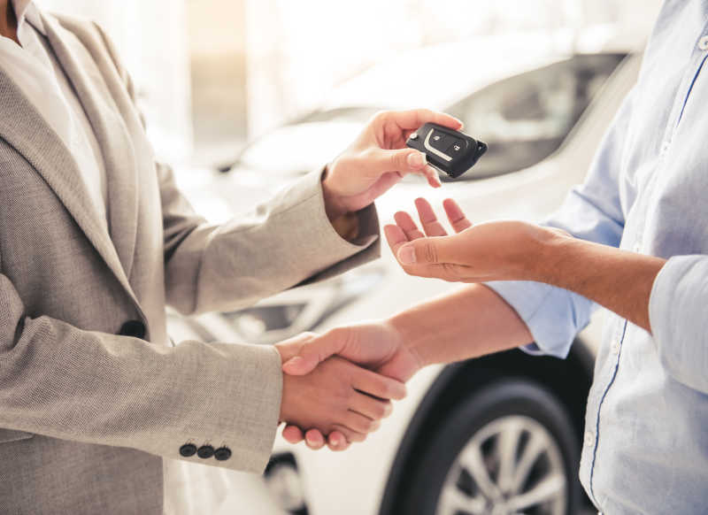 汽车经销商与顾客握手交付车钥匙