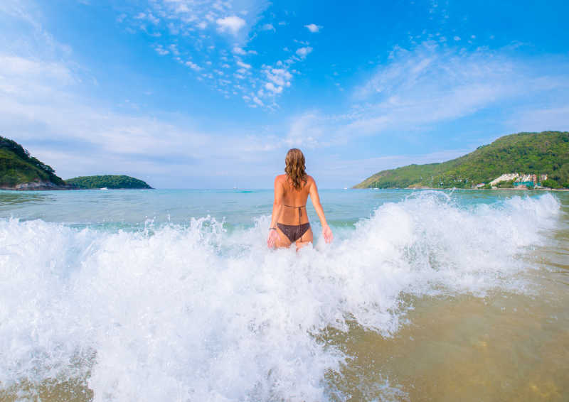 浪花拍在穿性感比基尼的美女身上