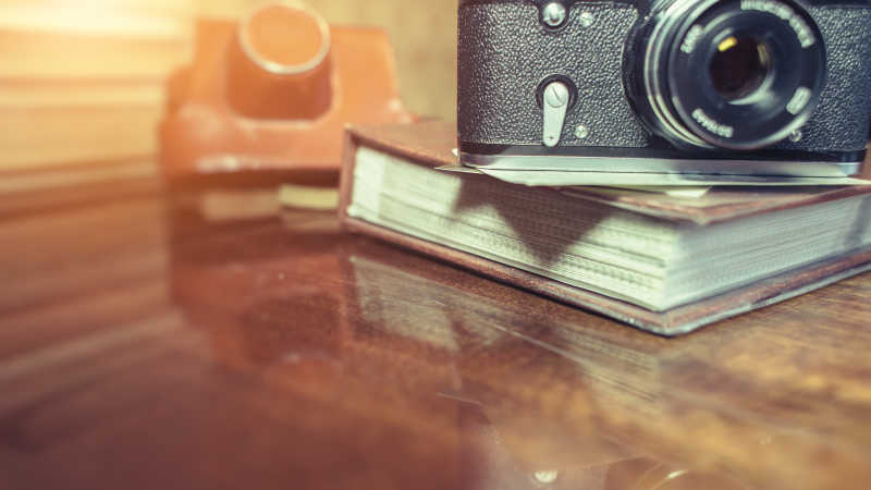 木桌上的相机和照片