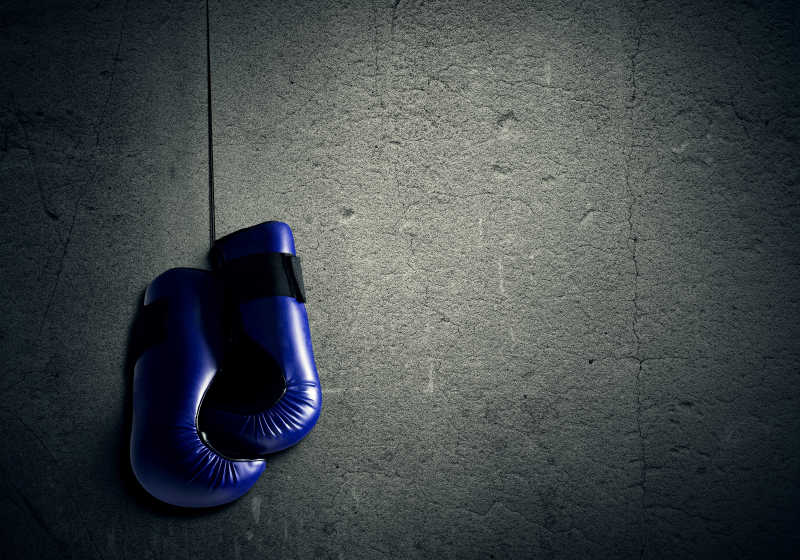 蓝色拳击手套挂在墙上
