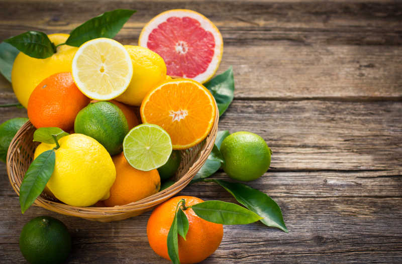在餐桌上的篮子里有新鲜多汁的柑橘类水果
