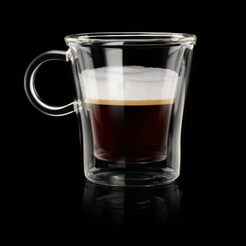 在黑色背景上的意大利浓咖啡玛奇朵透明玻璃杯