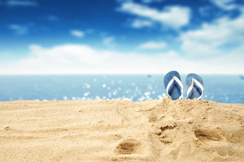 一双拖鞋在沙滩上