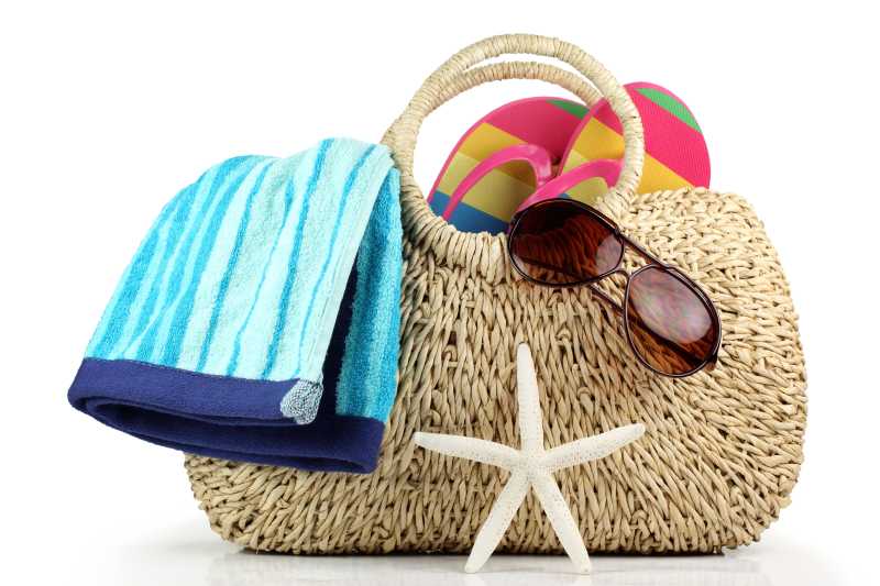 太阳镜和毛巾放在沙滩包上
