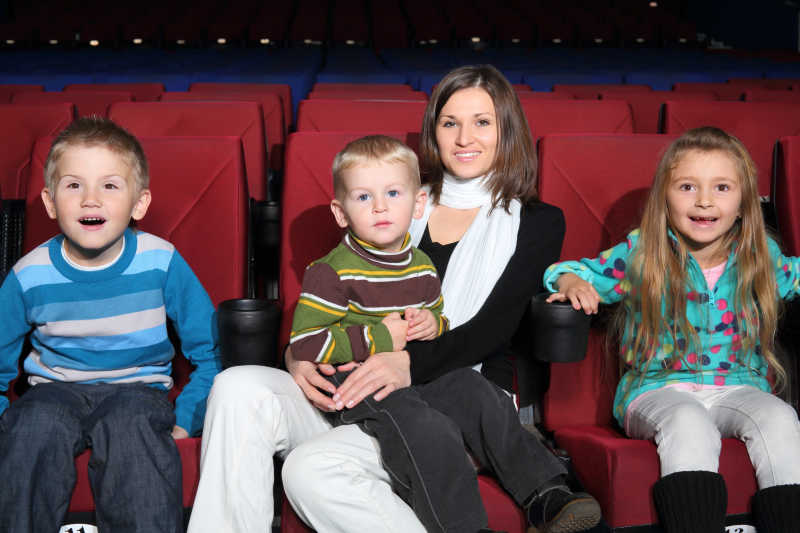 母亲带着孩子在电影院看电影