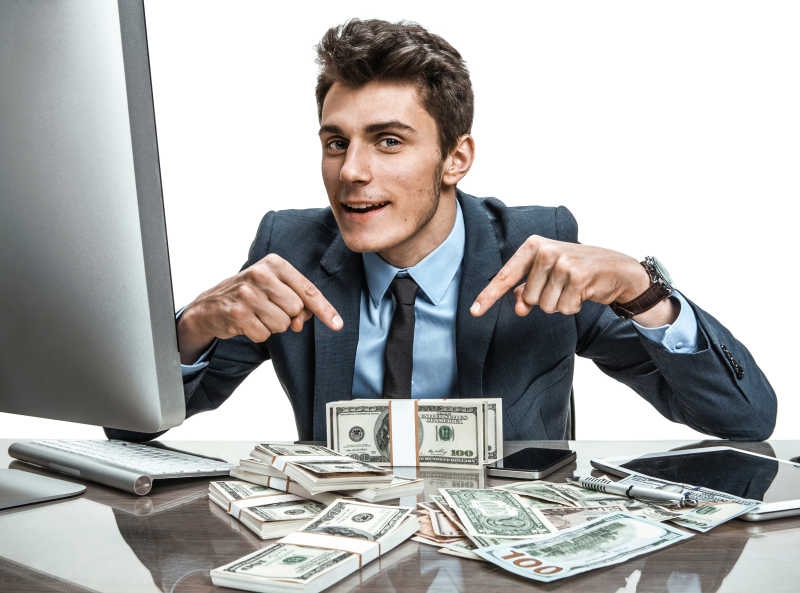 一个男人在有电脑的办公桌上展示收入