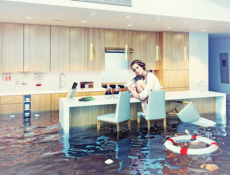 坐在被水淹没的厨房里的女人