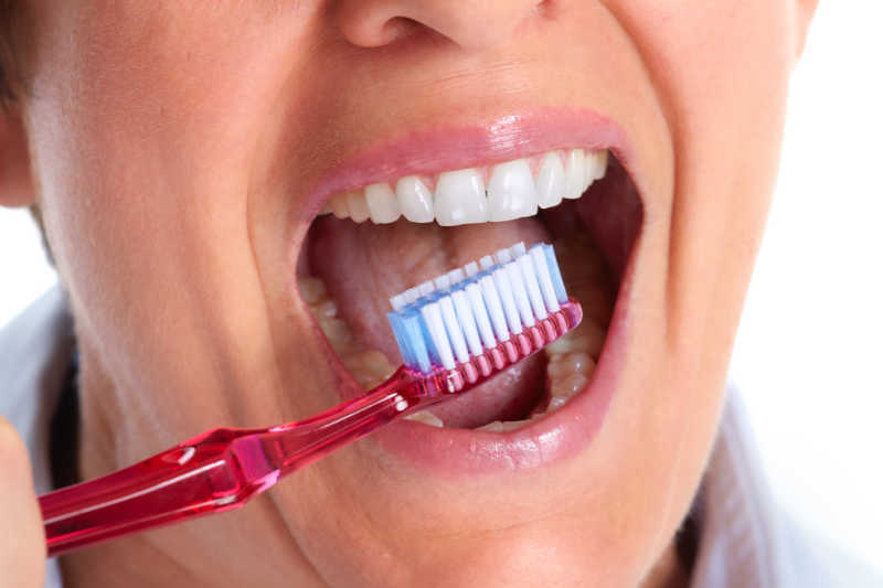 牙刷与露出的健康的牙齿