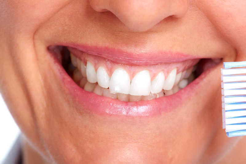 笑露出的健康洁白的牙齿与牙刷