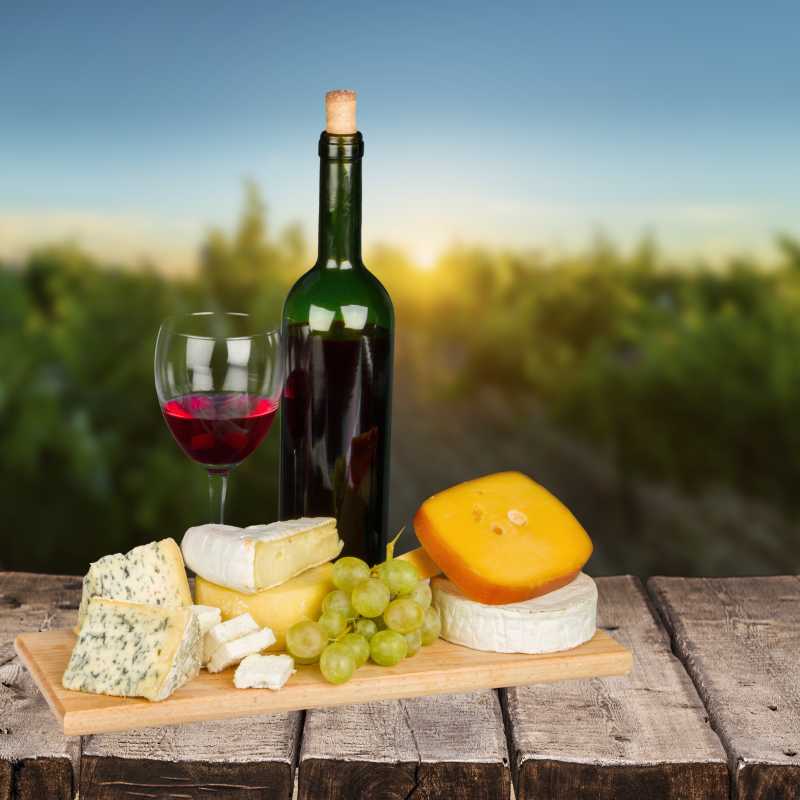 木板上的起司奶酪葡萄以及红酒
