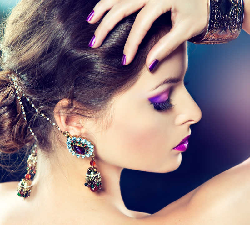 紫色化妆和修指甲的美丽模特