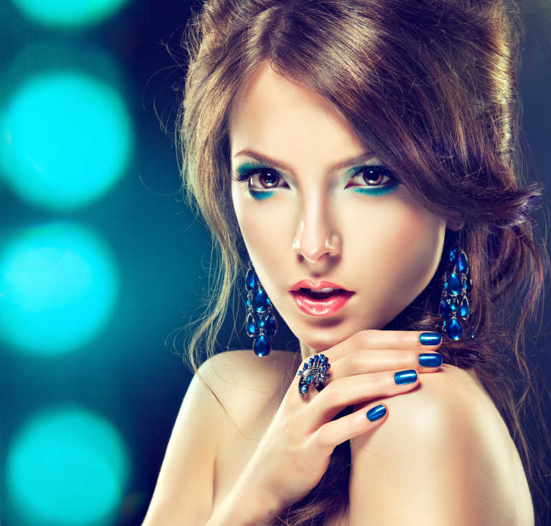 蓝色化妆和修指甲的美丽女孩妆容
