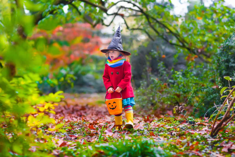公园里穿着小女巫服装的小女孩