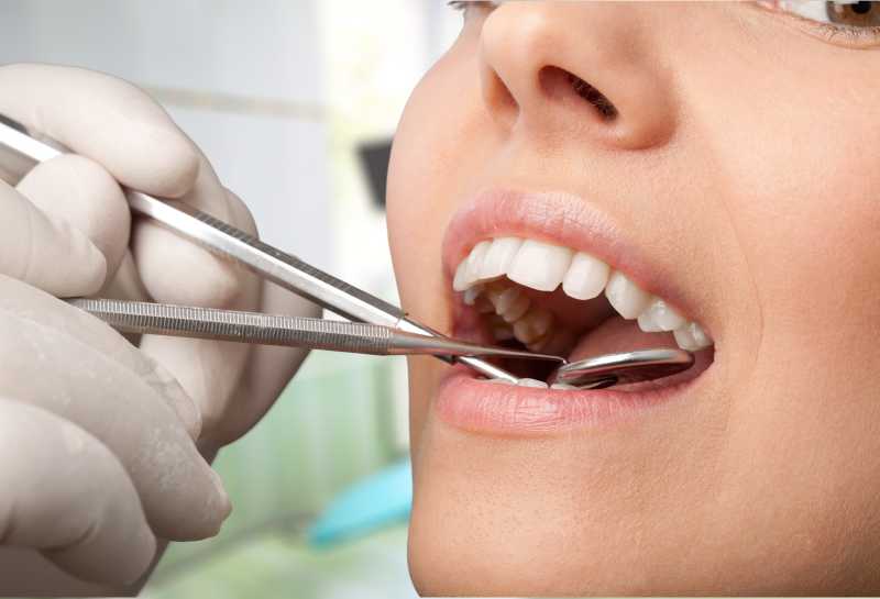 女人在接受用工具辅助的牙齿检查