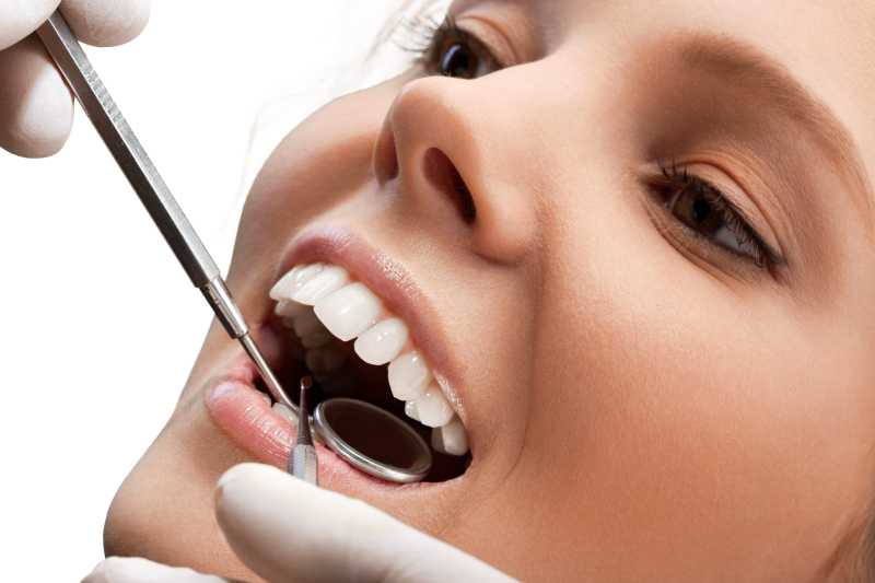 牙医拿着工具在做牙齿检查