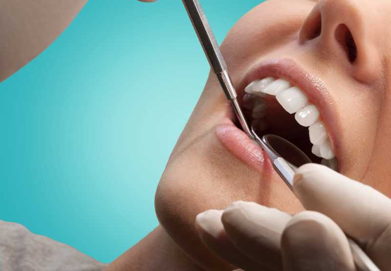 牙医拿着工具给女人做牙齿检查
