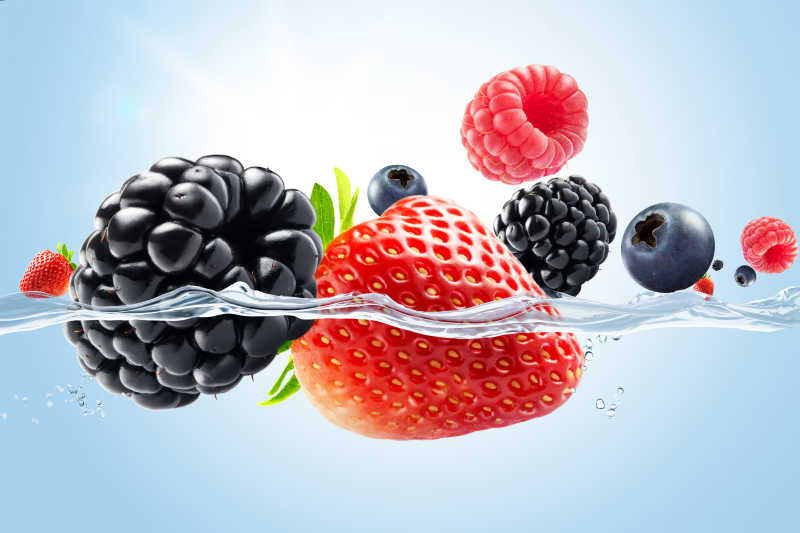 飞溅到水中的黑莓草莓和蓝莓等浆果特写