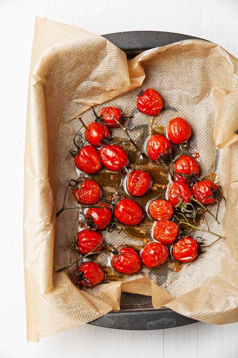 烤番茄配香草和橄榄油放在烤盘上