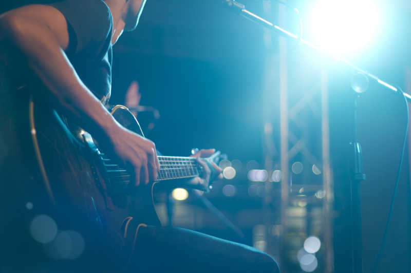 舞台背景下吉他手在弹吉他