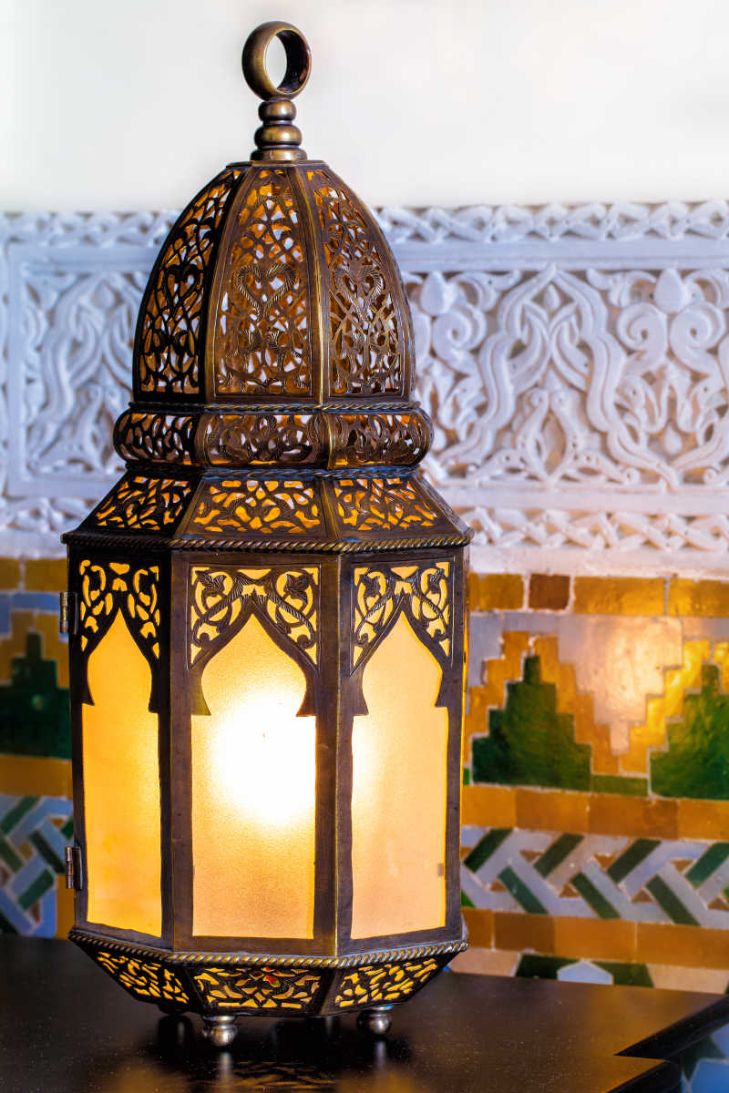 白色背景下散发着暖光的摩洛哥式灯笼