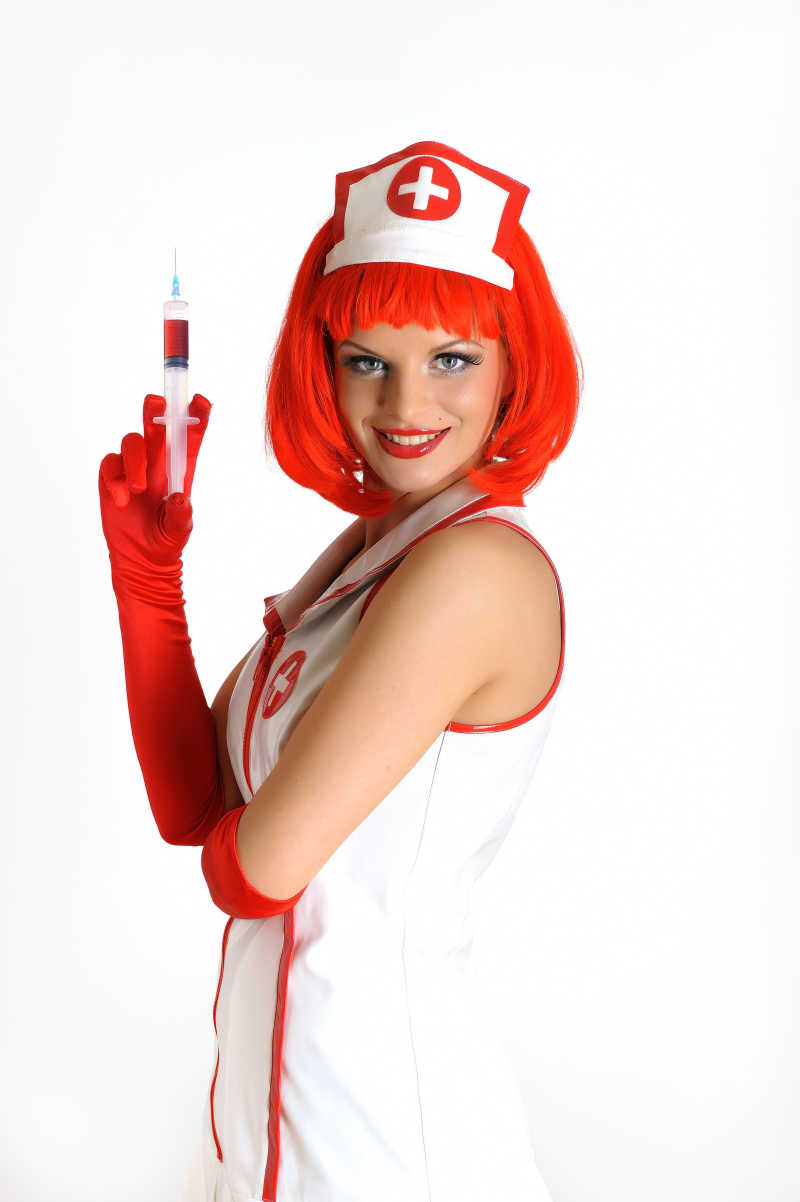 戴着红色假发拿着注射器的性感护士
