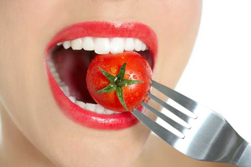 吃一个红色西红柿的女人嘴