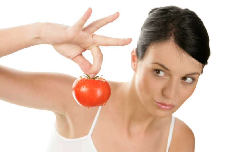 年轻女子拿着番茄