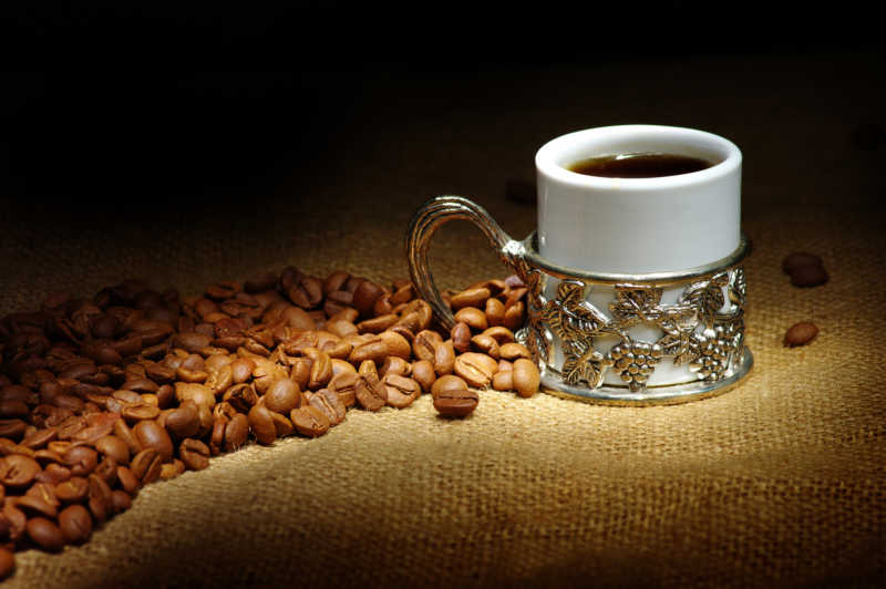 白色复古杯里的咖啡和咖啡豆
