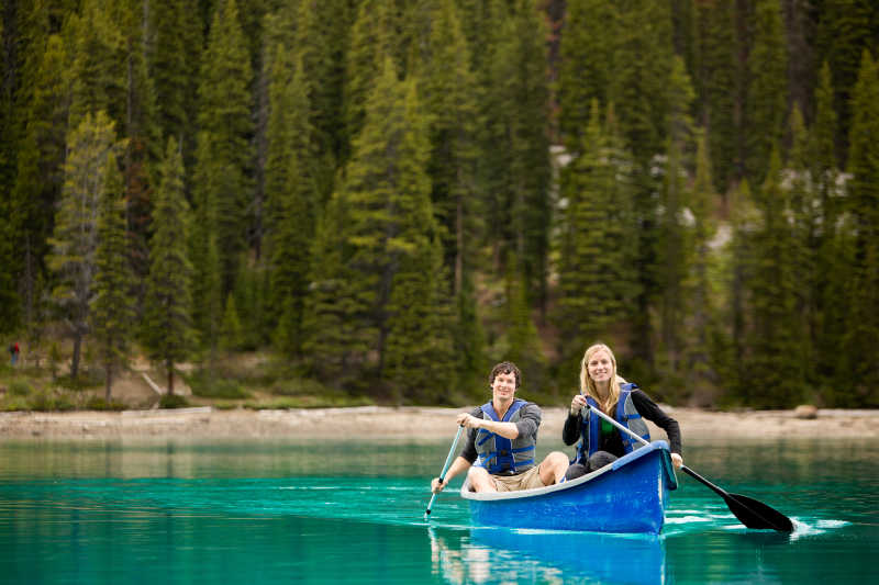 在湖面上划独木舟的夫妻
