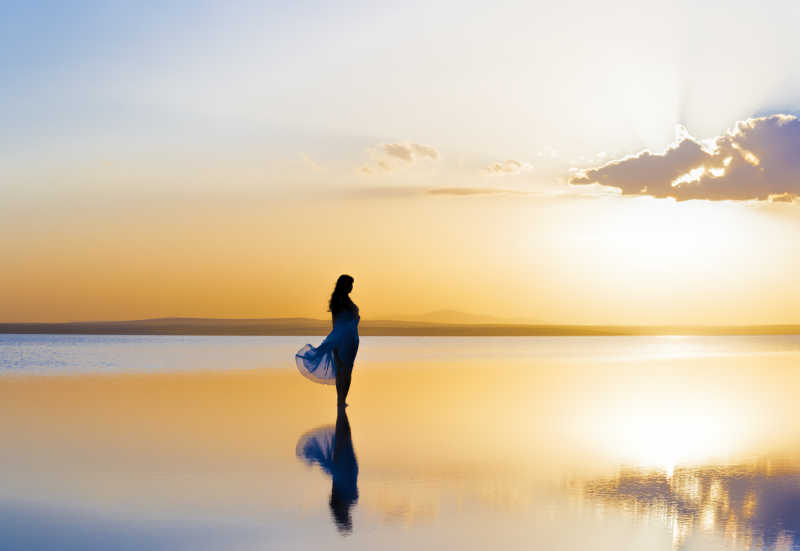 站在夕阳河水中的女人特写