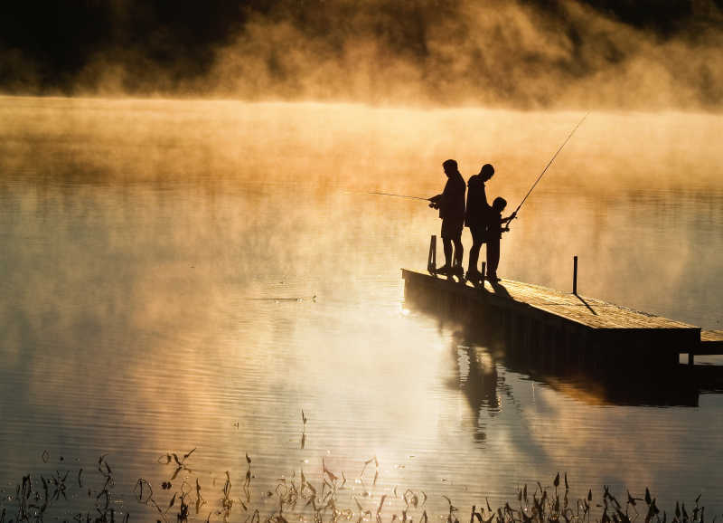 清晨在湖上码头钓鱼的家庭